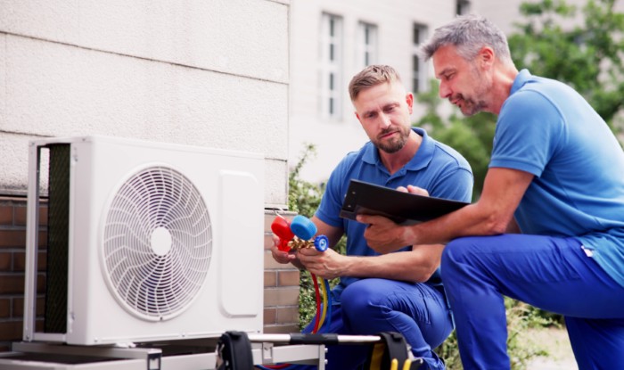 HVAC technicians reviewing an outdoor air conditioning unit in Vail, AZ