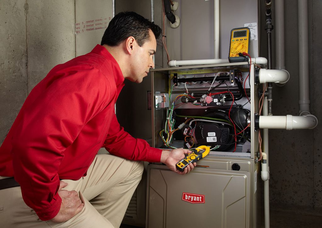 Heating and air conditioning technician servicing an indoor furnace in Vail, AZ