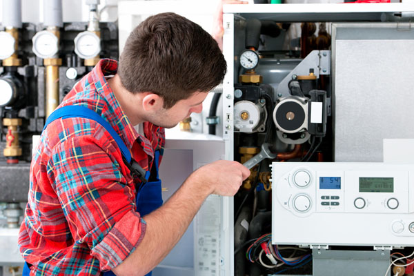 HVAC technician inspecting an indoor heating system in Vail, AZ