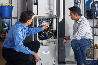 65df8c11f3e4c468cbd351a5_furnace repair vs replacement – Copy HVAC technician explaining furnace repair and maintenance to a homeowner in Vail, AZ