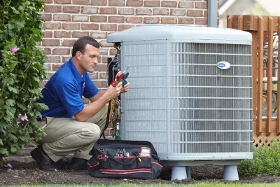 design-air-heating-and-air-conditioning-decatur-il-05 – Copy HVAC technician inspecting an outdoor air conditioning unit in Vail, AZ