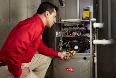 furnace repair Heating and air conditioning technician servicing an indoor furnace in Vail, AZ